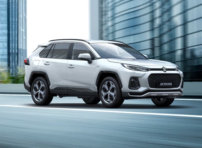 Jégfehér Suzuki Across halad egy városi úton